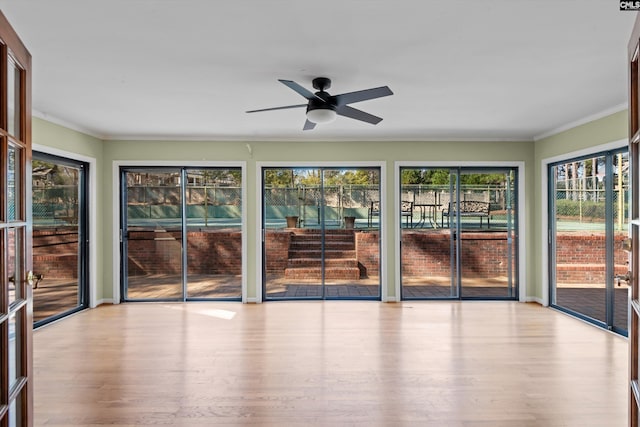 unfurnished sunroom with a ceiling fan