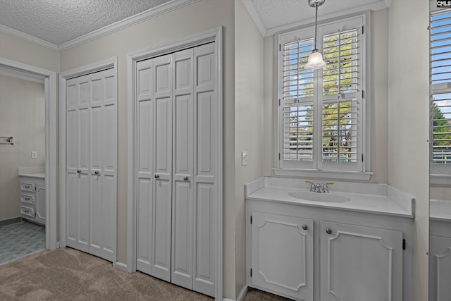 bathroom featuring a textured ceiling, a closet, vanity, and crown molding