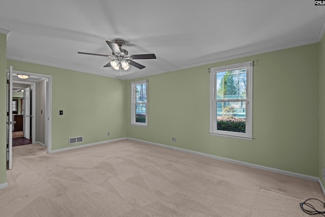 unfurnished room featuring light carpet, baseboards, visible vents, ceiling fan, and crown molding