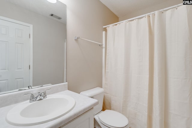 bathroom featuring visible vents, a textured ceiling, toilet, and vanity