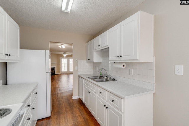 kitchen featuring decorative backsplash, ceiling fan, dark wood-style flooring, white cabinetry, and a sink