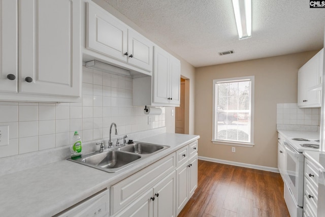 kitchen with white electric range oven, light countertops, visible vents, dark wood-type flooring, and white cabinets