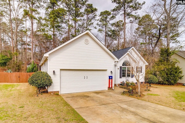 view of front of home featuring driveway, an attached garage, fence, and a front yard