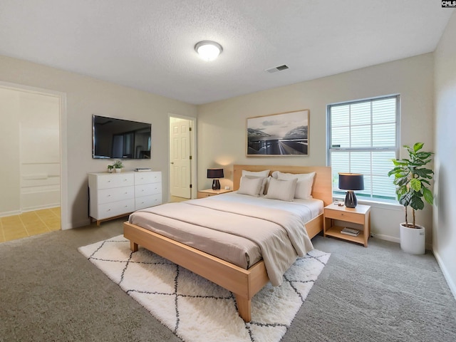 bedroom with a textured ceiling, carpet, visible vents, and baseboards