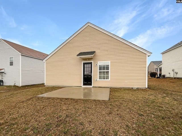 back of property with central air condition unit, a lawn, and a patio