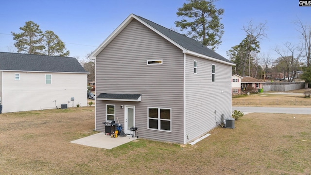 back of property with cooling unit, a yard, and a patio