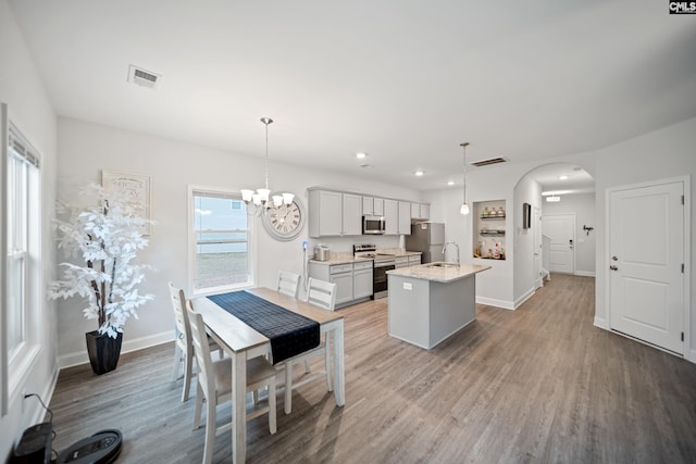 kitchen with visible vents, appliances with stainless steel finishes, arched walkways, and a sink