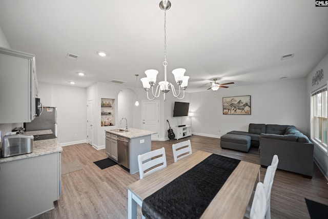 dining area with baseboards, visible vents, and light wood finished floors