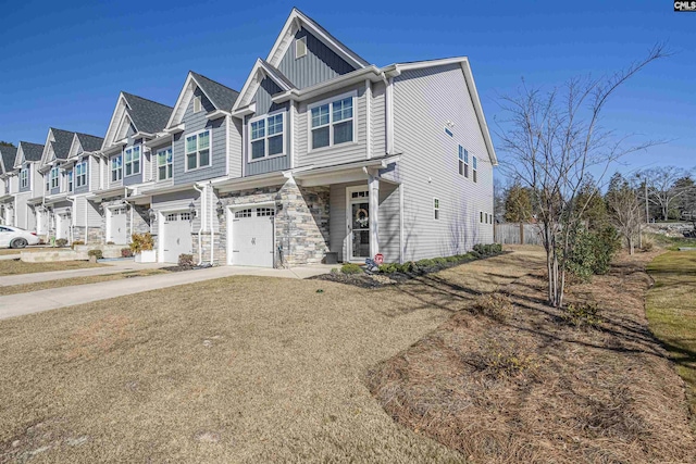 view of front of home featuring concrete driveway, stone siding, a residential view, an attached garage, and board and batten siding