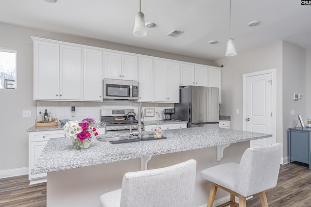 kitchen featuring stainless steel appliances, dark wood-style flooring, backsplash, and visible vents