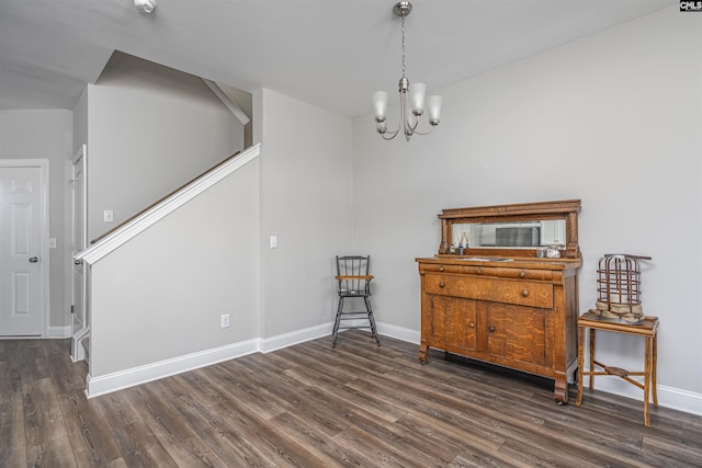 living area with dark wood-style floors, stairs, baseboards, and a chandelier