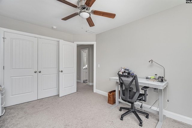 home office featuring baseboards, a ceiling fan, visible vents, and light colored carpet