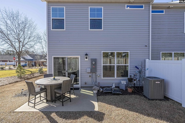 rear view of property featuring outdoor dining area, a patio, fence, and central AC unit