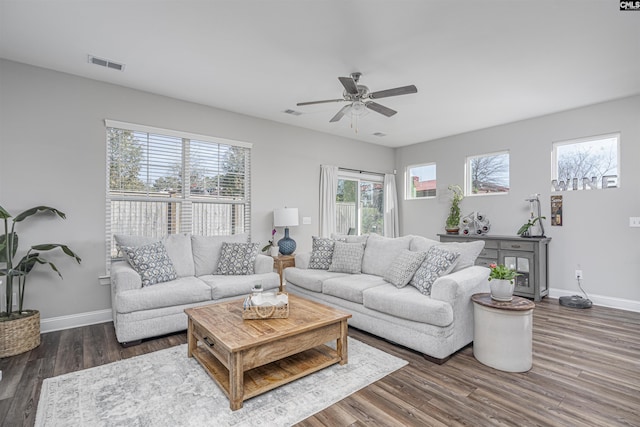 living area with visible vents, ceiling fan, baseboards, and wood finished floors