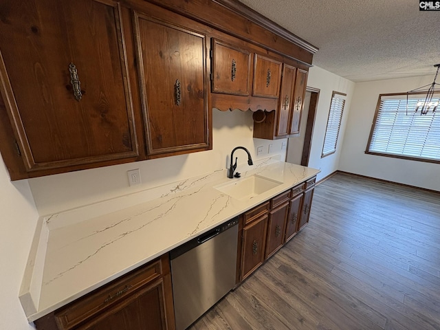 kitchen featuring dark wood-style flooring, a notable chandelier, a textured ceiling, stainless steel dishwasher, and a sink