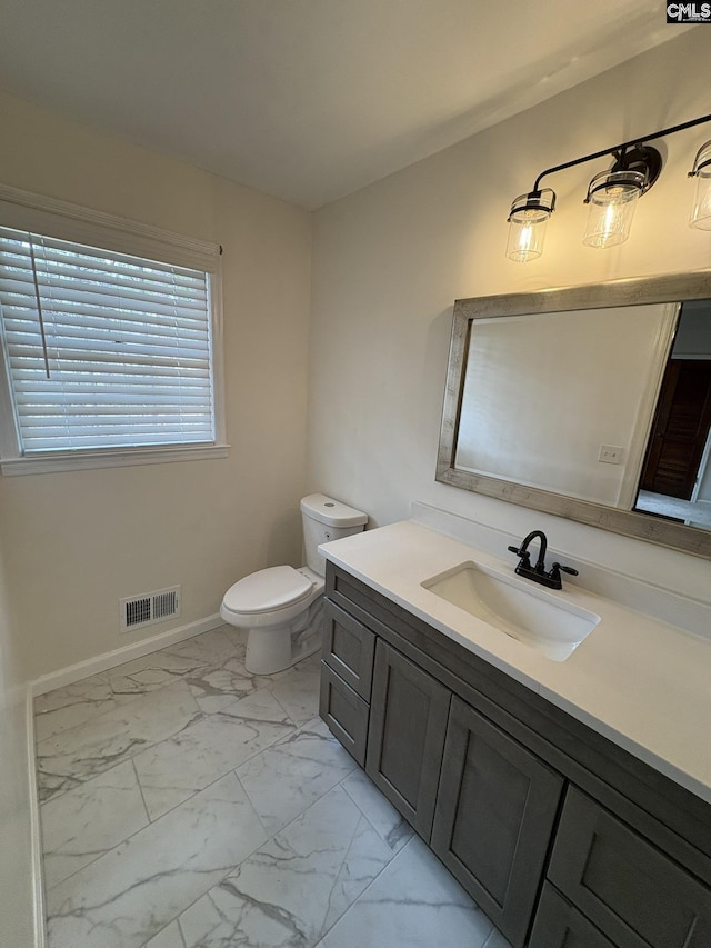 bathroom featuring baseboards, visible vents, toilet, marble finish floor, and vanity