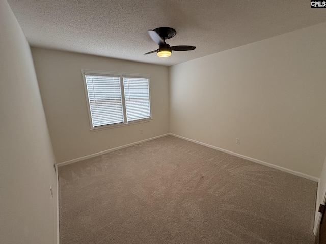 empty room with a textured ceiling, carpet flooring, and baseboards