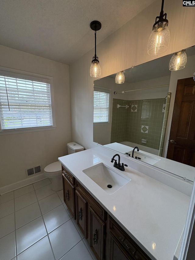 bathroom featuring visible vents, a textured ceiling, vanity, tiled shower, and tile patterned floors