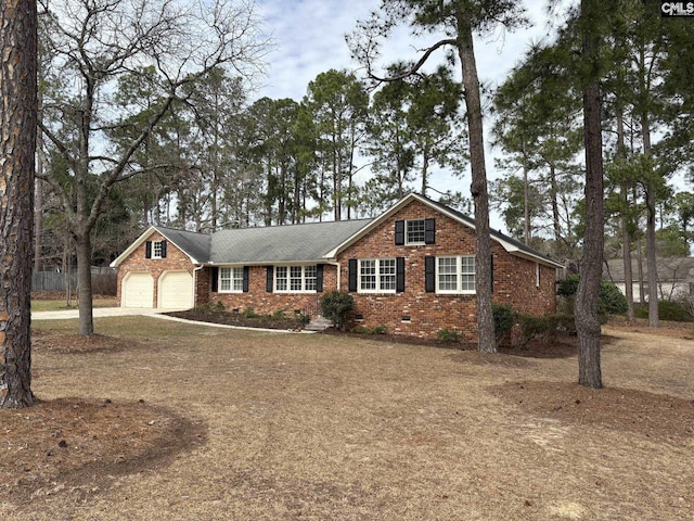 view of front of property with driveway, brick siding, crawl space, and an attached garage