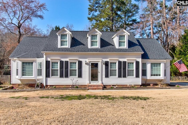 cape cod house featuring a front lawn and roof with shingles