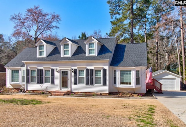 cape cod home featuring a front lawn, an outdoor structure, a detached garage, and a shingled roof