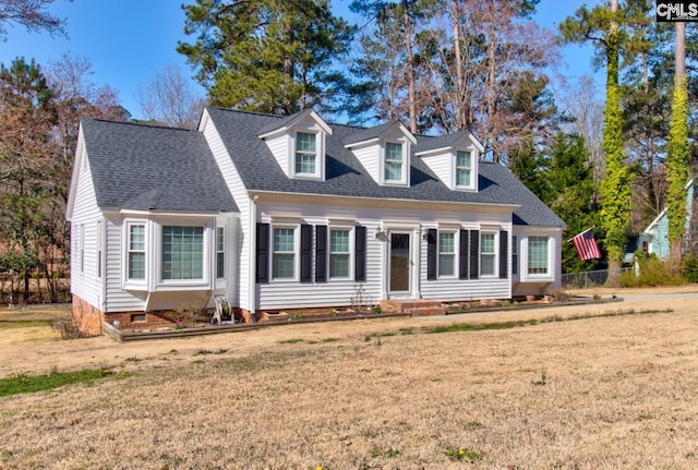 new england style home featuring crawl space, roof with shingles, and a front yard