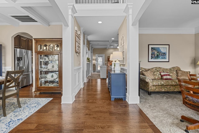 entrance foyer with arched walkways, coffered ceiling, visible vents, beam ceiling, and dark wood finished floors