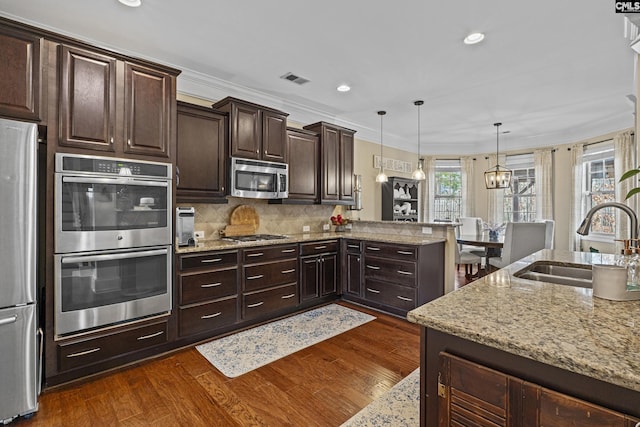 kitchen with tasteful backsplash, appliances with stainless steel finishes, dark wood-type flooring, and a sink