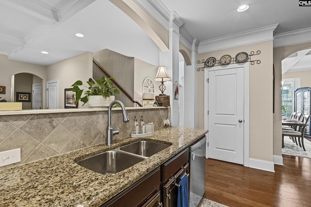 kitchen with ornamental molding, stainless steel dishwasher, a sink, and dark wood finished floors