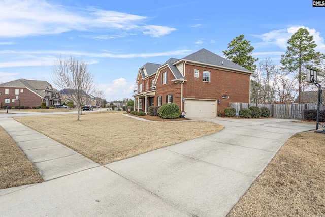 view of property exterior featuring a garage, driveway, fence, and brick siding