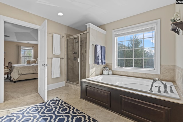 bathroom with a shower stall, a bath, and ensuite bathroom