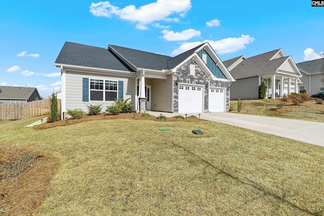 view of front of home with concrete driveway, a front yard, fence, a garage, and stone siding