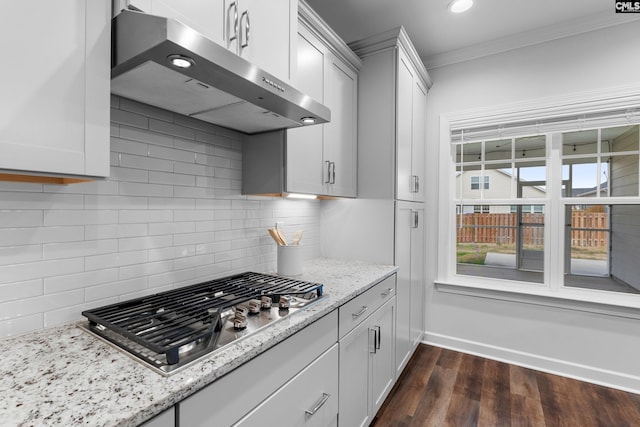 kitchen with range hood, stainless steel gas stovetop, ornamental molding, dark wood-type flooring, and baseboards