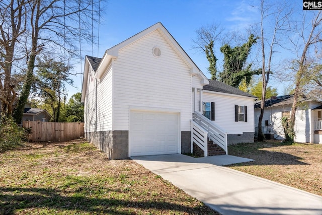 view of property exterior with a garage, crawl space, fence, and driveway