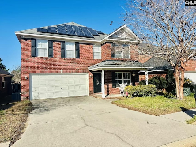 view of front of home with solar panels, concrete driveway, and brick siding