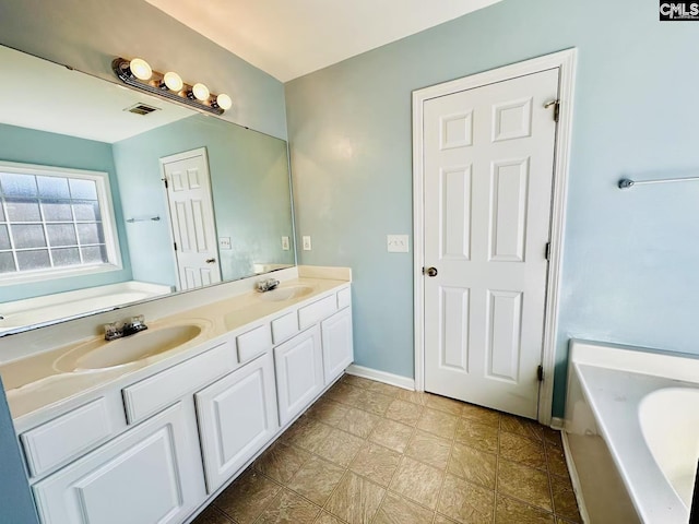 full bathroom featuring a washtub, double vanity, a sink, and visible vents