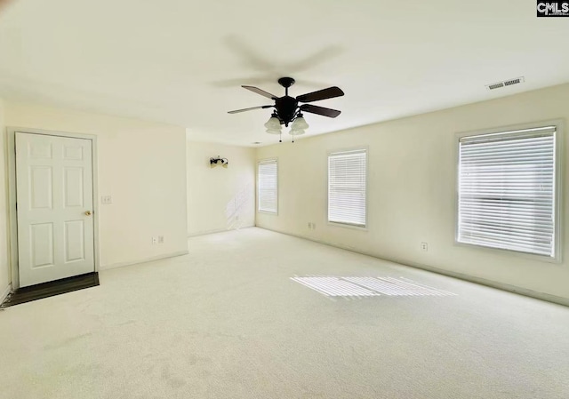 empty room with visible vents, ceiling fan, and carpet flooring