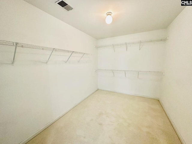 walk in closet featuring light carpet and visible vents