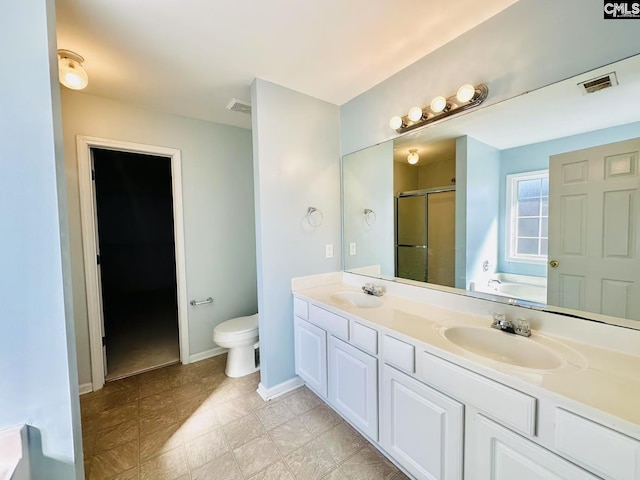 bathroom featuring a stall shower, visible vents, a sink, and toilet