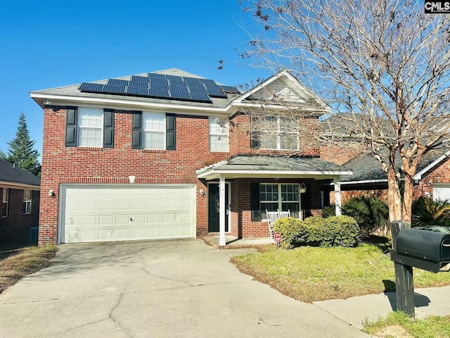 view of front of property featuring solar panels, concrete driveway, and brick siding