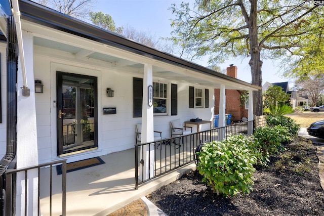 entrance to property with covered porch and a chimney