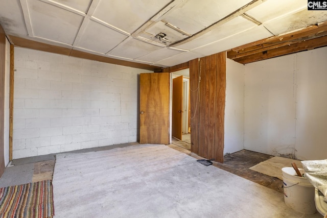 unfurnished room featuring concrete flooring and concrete block wall