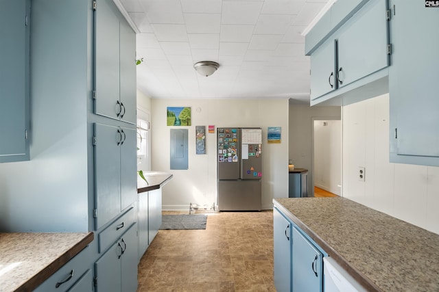 kitchen featuring blue cabinetry, electric panel, light countertops, and freestanding refrigerator