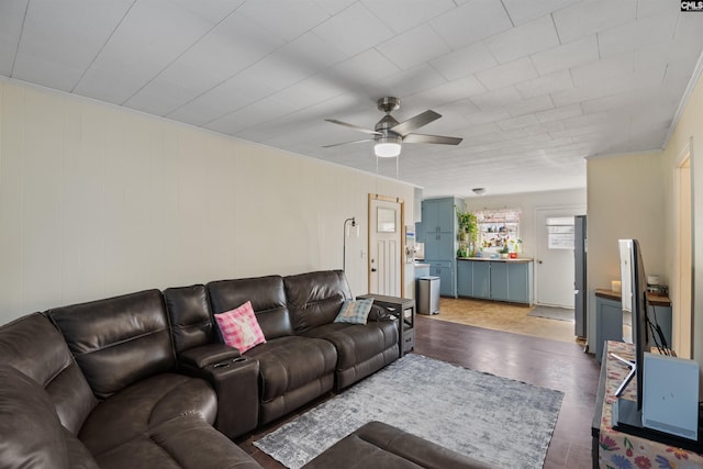 living area with a ceiling fan and wood finished floors