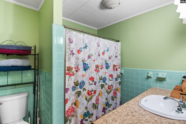 bathroom with wainscoting, a sink, tile walls, and a shower with shower curtain