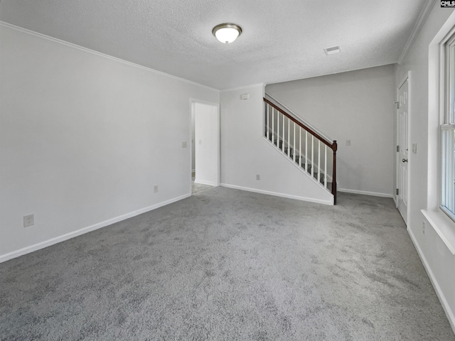 interior space with a textured ceiling, stairway, carpet flooring, and crown molding