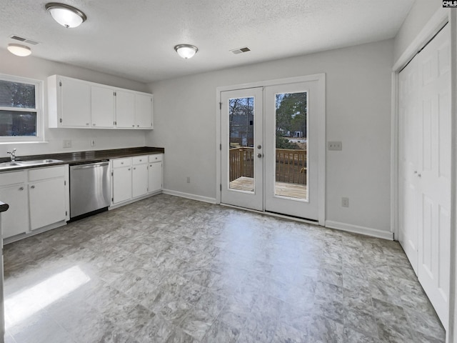 kitchen with a sink, baseboards, white cabinets, dishwasher, and dark countertops