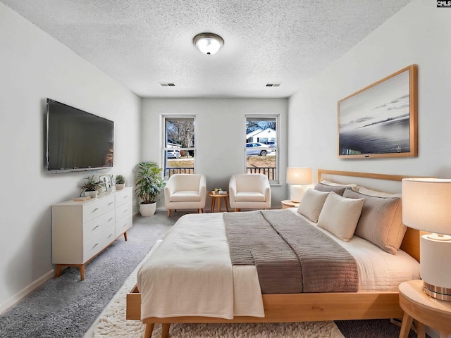 carpeted bedroom with baseboards, visible vents, and a textured ceiling