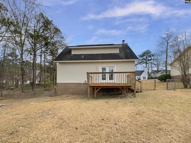 rear view of property featuring fence and a wooden deck