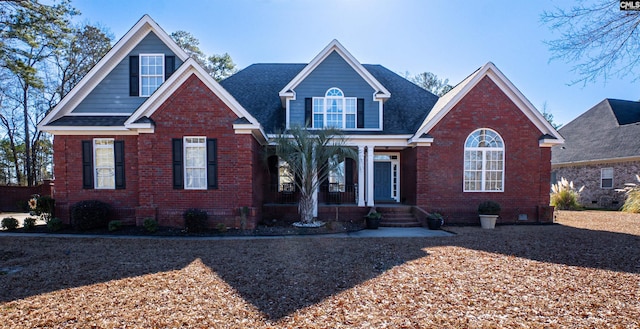 view of front facade featuring a porch, brick siding, and a shingled roof